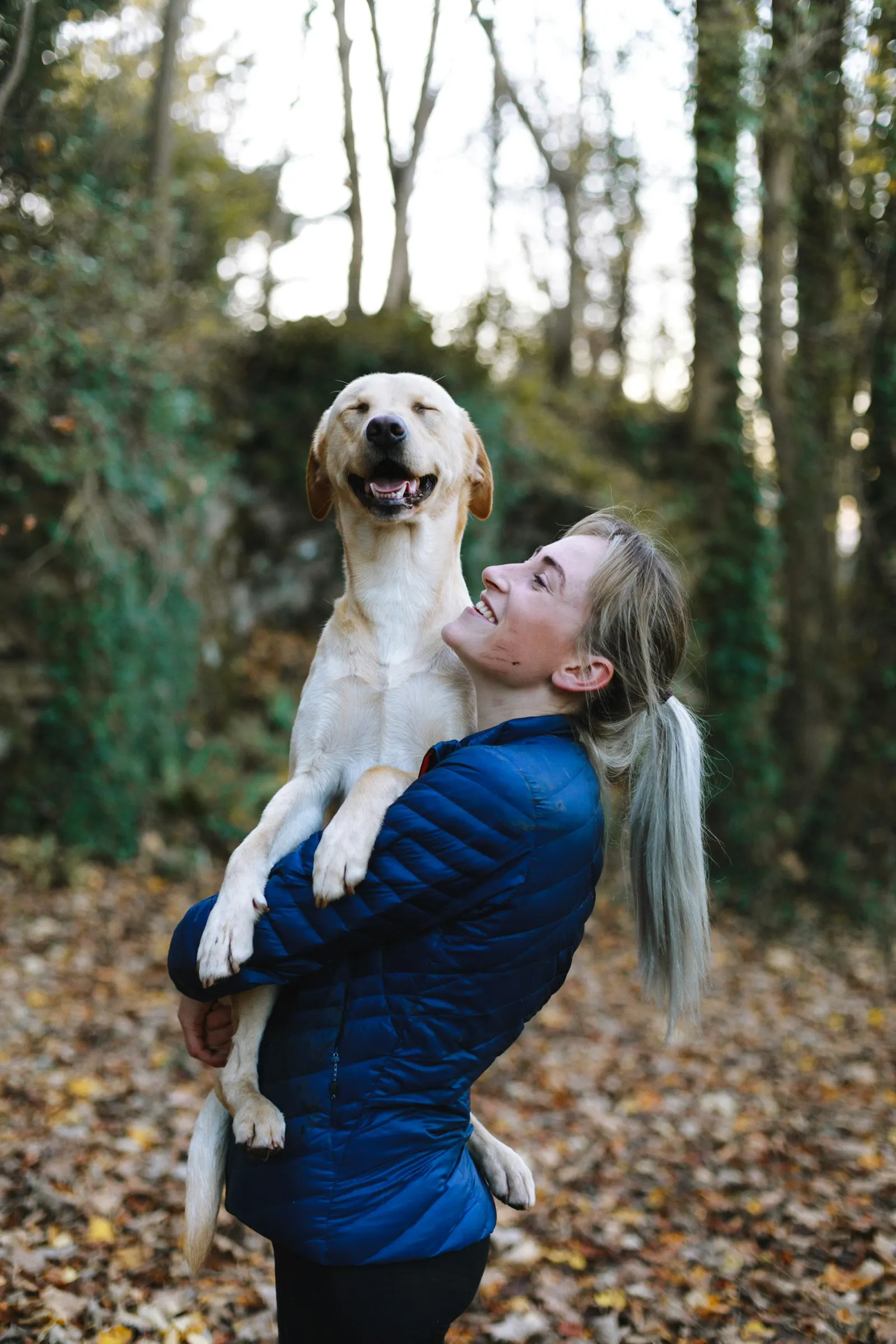 Köpeğini kucağında taşıyan bir kadın